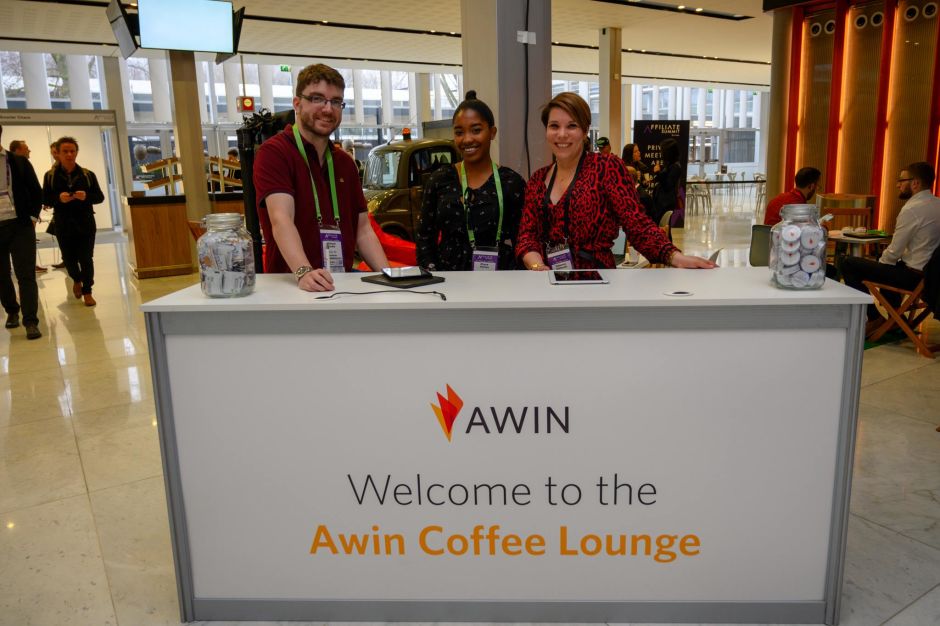 Tre membri dello staff Awin all'accoglienza dell'area lounge