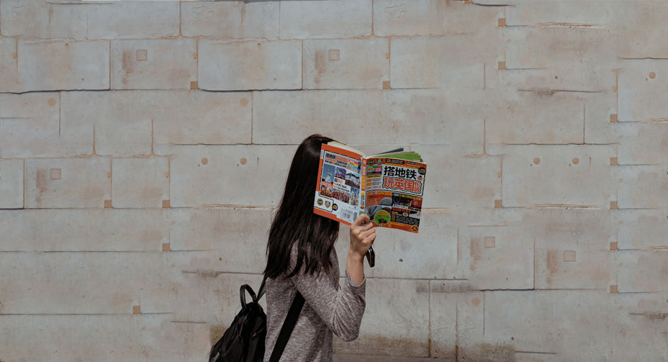 Ragazza che si nasconde dietro a un libro