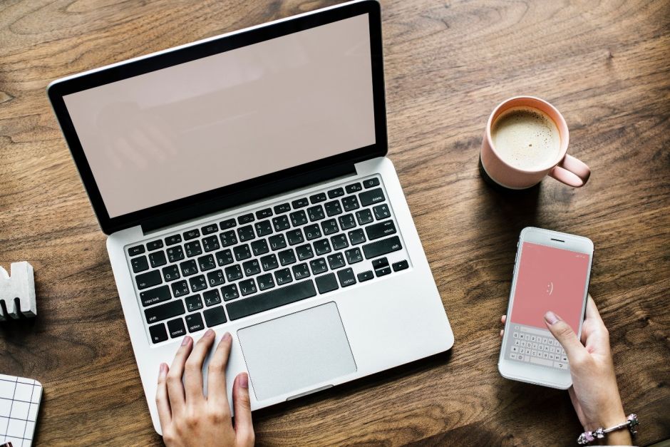 Laptop in una mano e telefono dall'altra