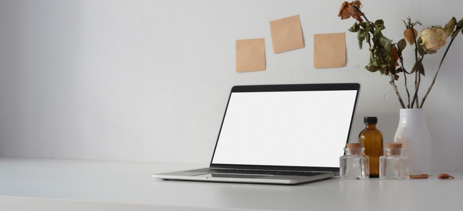 Immagine di un computer acceso in una postazione di smart working.