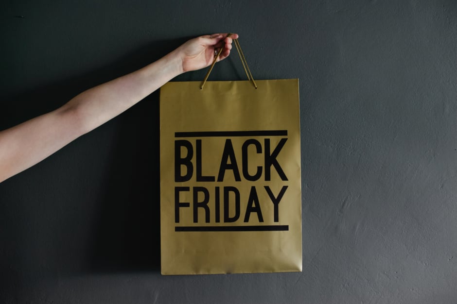 fotografia di un sacchetto in carta con sopra scritta Black Friday tenuto da una mano