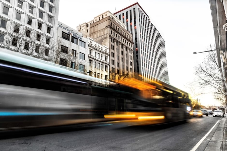 An image of blurred traffic passing through a commercial area.