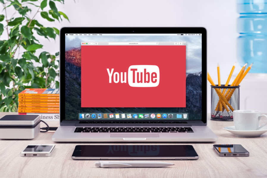 An image of an Apple Mac laptop on a desktop with 'Youtube' on screen.